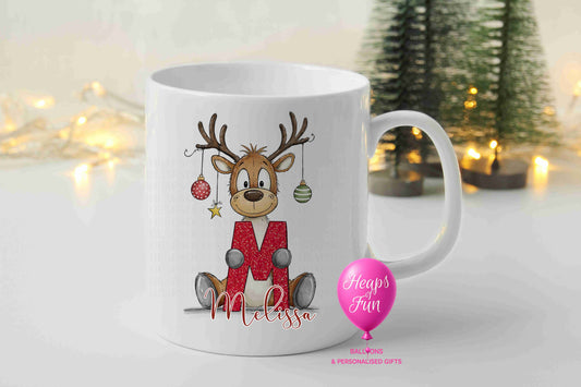 Personalised reindeer Christmas mug holding red glitter initial with baubles and name